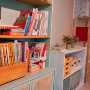 Ein Regal an einer Wand mit Kinderbüchern
